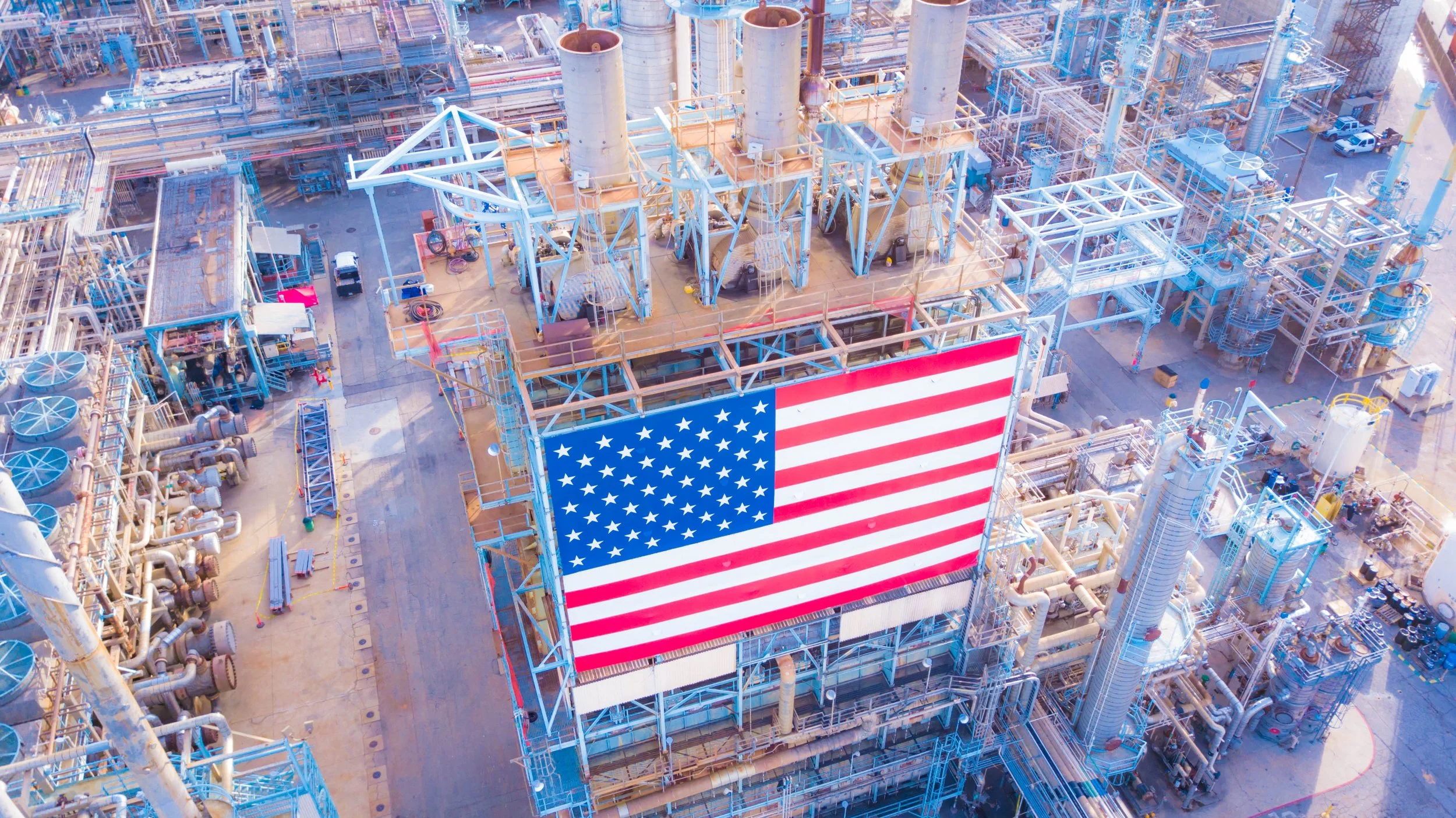 American flag displayed above an industrial manufacturing facility