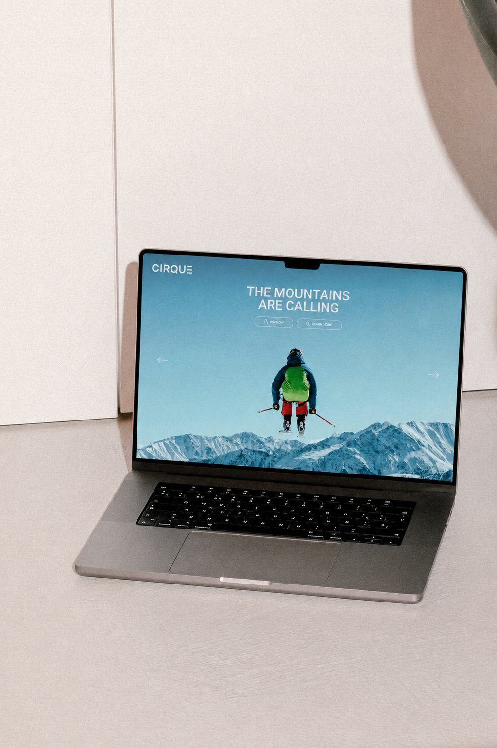 Laptop displaying an outdoor adventure website with a mountain climber on a snowy mountain background.