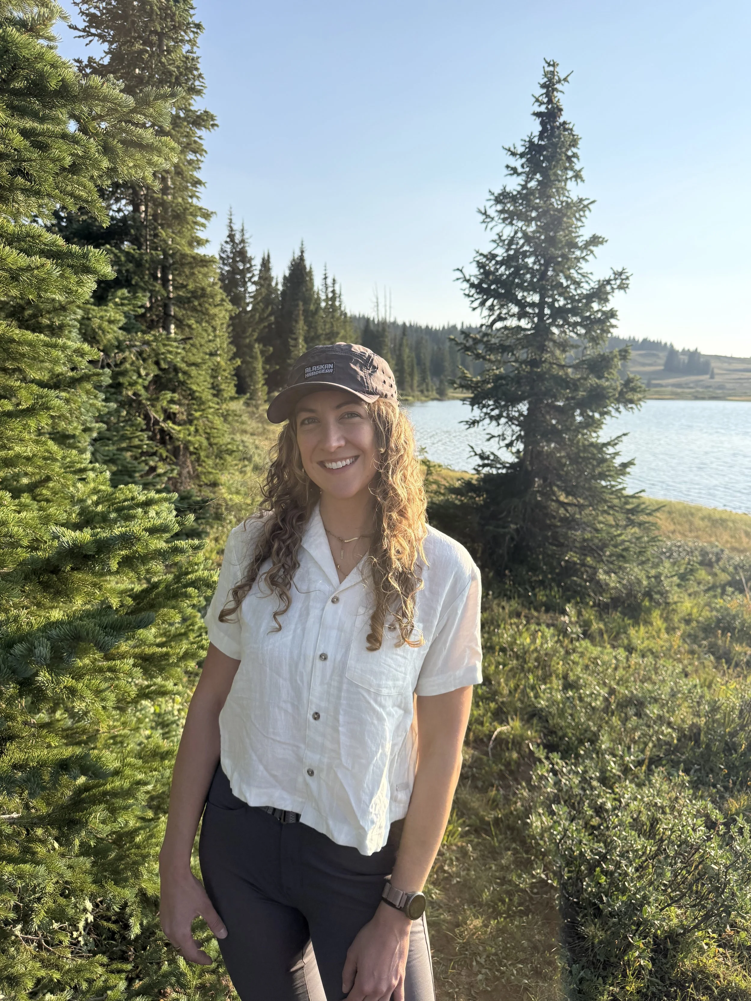 Stephanie Hands, founder of Wildflower Nutrition, outdoors by a mountain lake in Colorado.