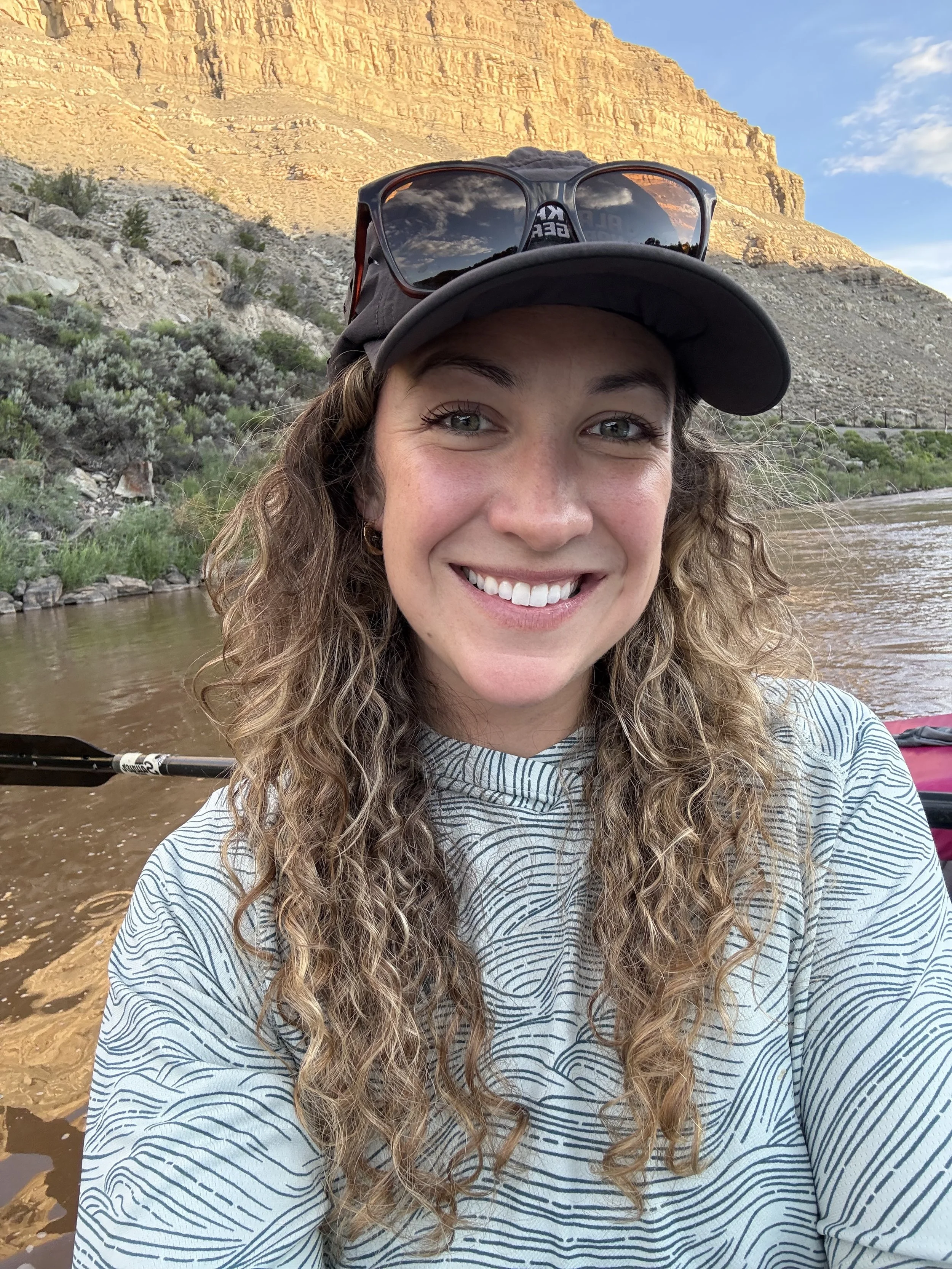 Stephanie Hands of Wildflower Nutrition smiling beside a river and layered rock formations in Colorado.