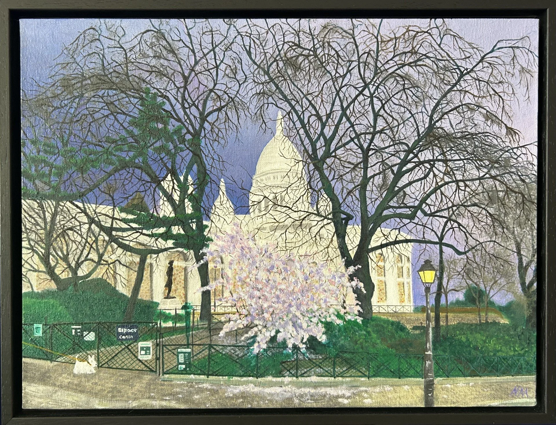 A painting of a park scene at night with leafless trees, a person walking their dog, and the Sacre-Coeur basilica, Montmartre, Paris illuminated in the background. There are also a dog park gate and some greenery in the foreground.