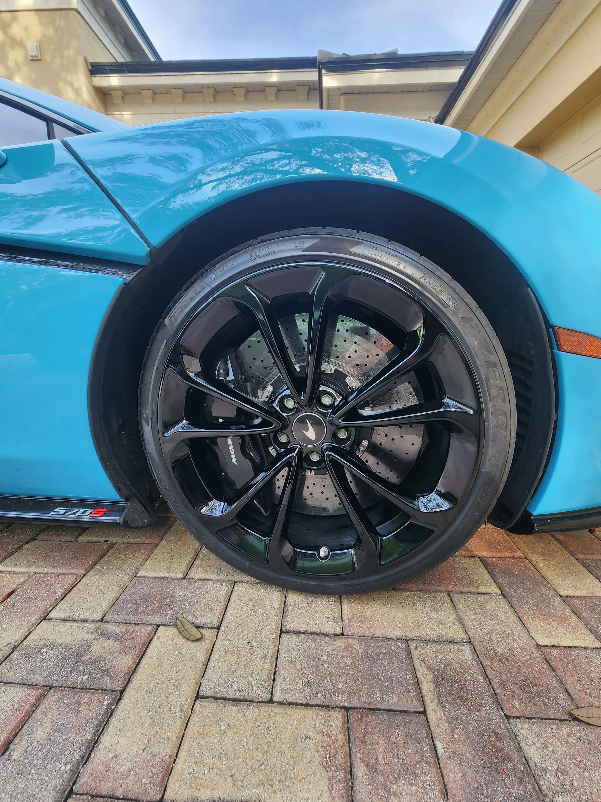 Expert gloss black wheel restoration and precision curb rash repair on a McLaren 570S. At AUTOESTHETICS in Tarpon Springs, FL, we specialize in high-end alloy wheel refinishing, custom powder coating, and exotic vehicle care serving Pinellas, Pasco, 