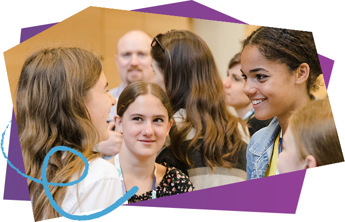 A group of smiling students engaging in a conversation at a social gathering or event.