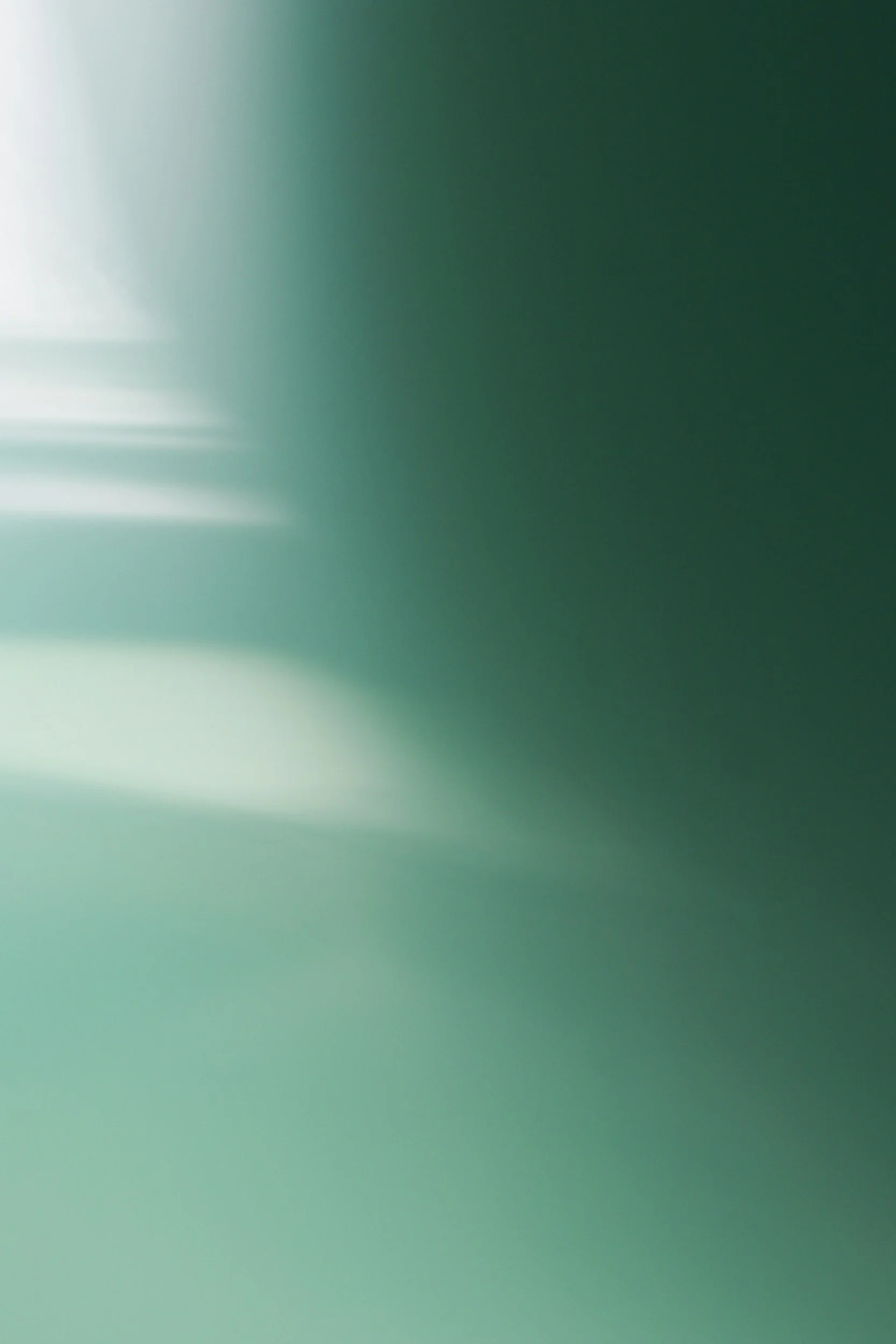 Blurred image with gradient shades of teal and light green.