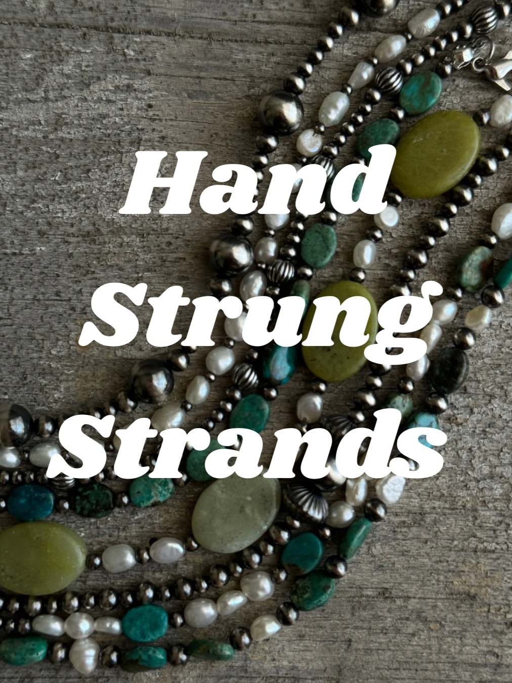 Close-up of layered necklaces made of various beads and stones on a wooden surface with the words "Hand Strung Strands" overlaid in white text.