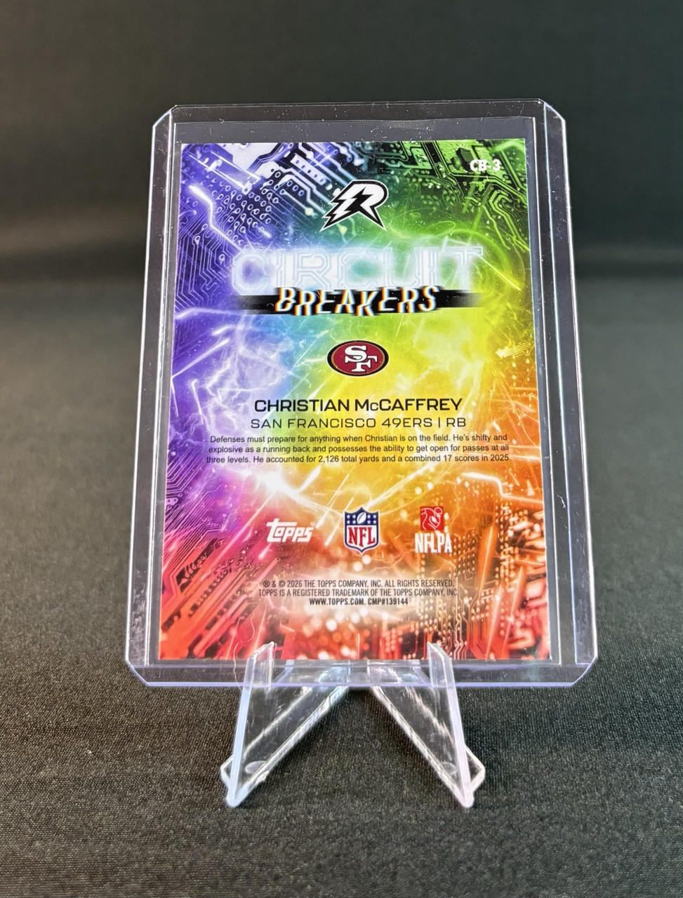 Colorful football trading card display featuring Christian McCaffrey from the San Francisco 49ers, with logos of Topps, NFL, and NFLPA.