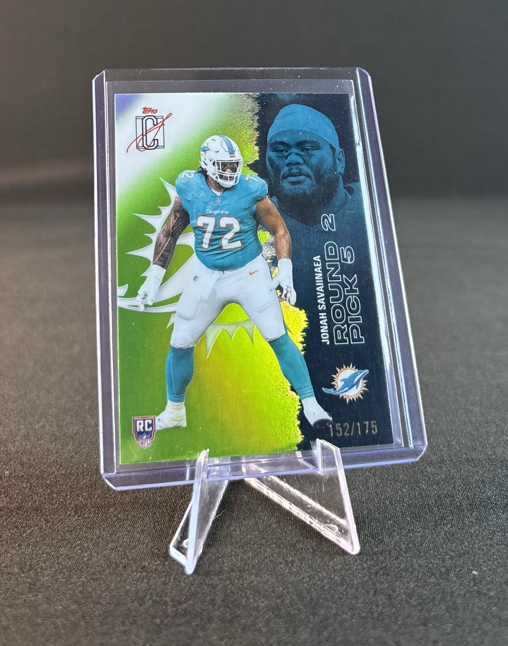 A collectible sports card featuring a football player from the Miami Dolphins wearing a number 72 jersey, alongside a large portrait of a man wearing a blue head covering. The card has a holographic background, the Topps logo in the top left corner, and the Miami Dolphins logo at the bottom right. It is numbered 152 out of 175 and is encased in a clear plastic protective holder.