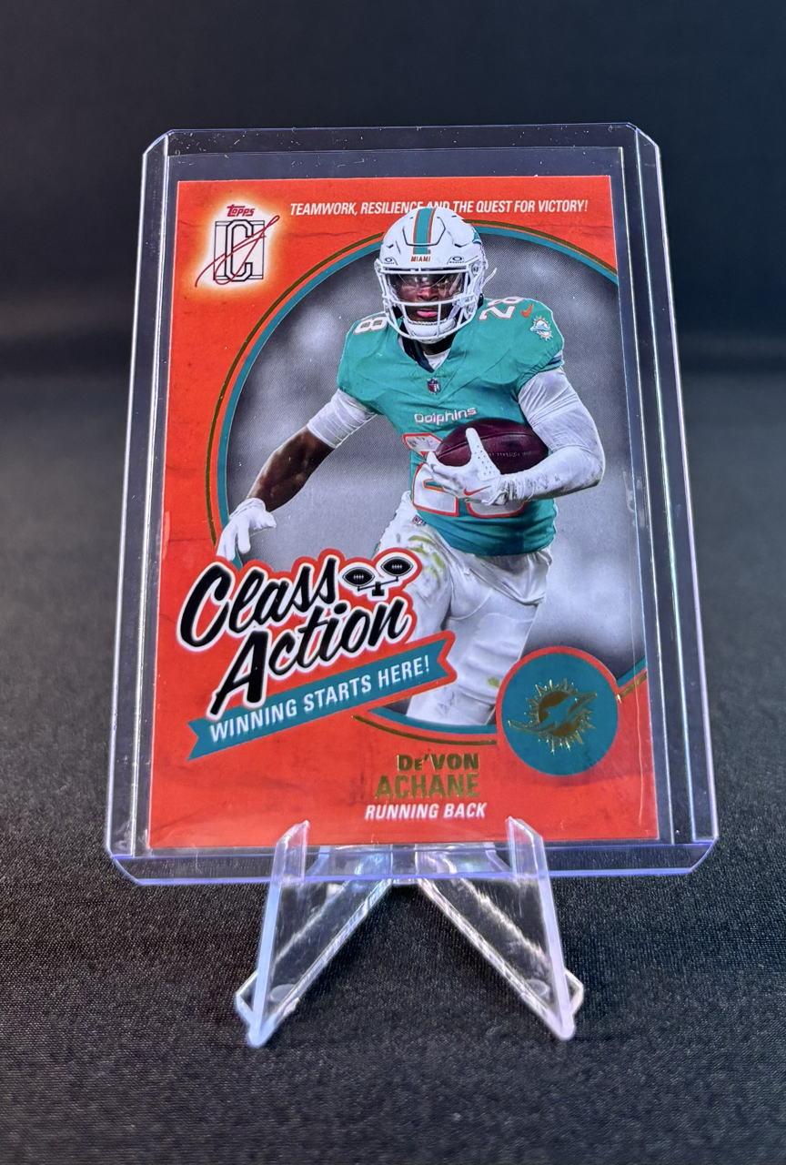 Sports card featuring De'VON Achane, a Miami Dolphins running back, in a teal and white uniform holding a football, with the text "Class Action, Winning Starts Here!" and the Dolphins logo in the lower right corner.