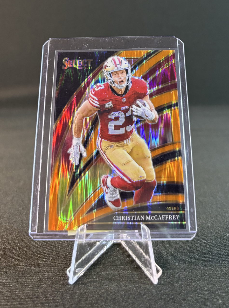 Holographic football trading card of Christian McCaffrey in a red uniform, running with a football, displayed on a small stand.