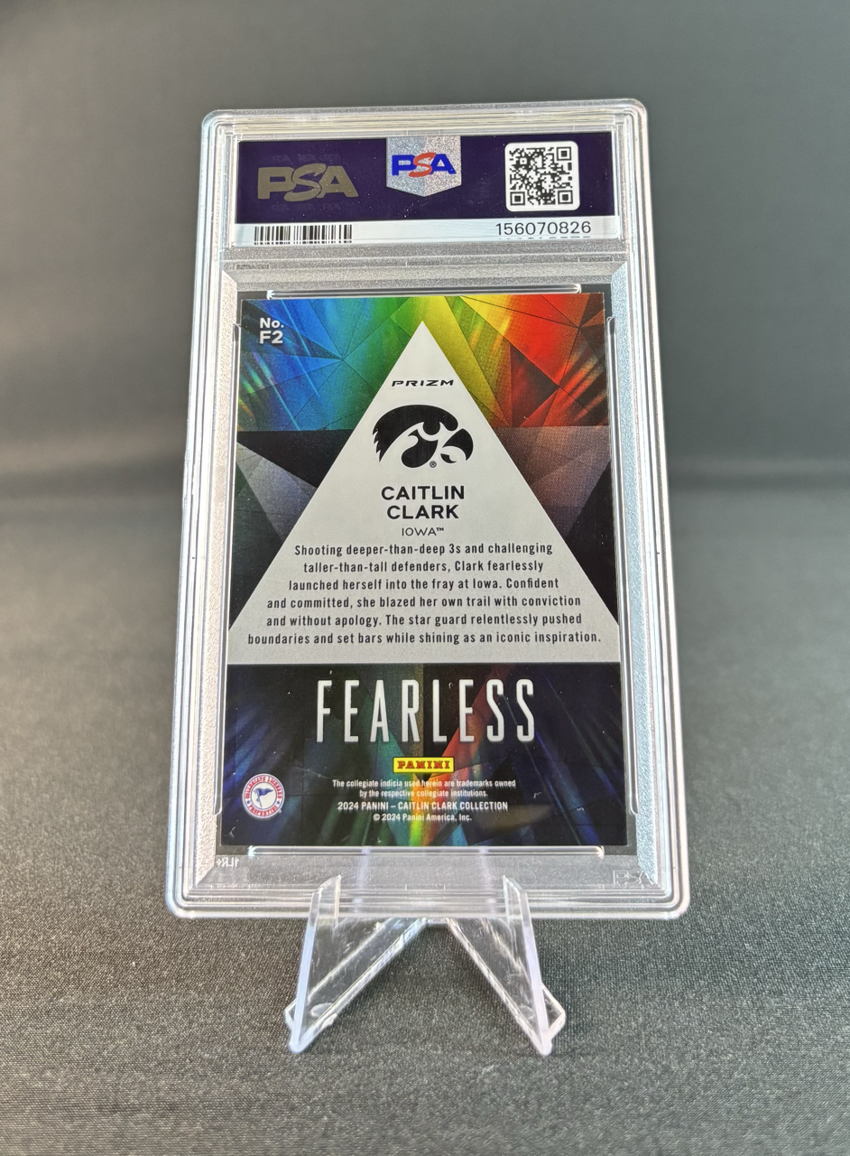A collectible sports card encased in a clear plastic protective case with a PSA certification label at the top, featuring Caitlin Clark from Iowa on the 2024 Panini Fearless collection.