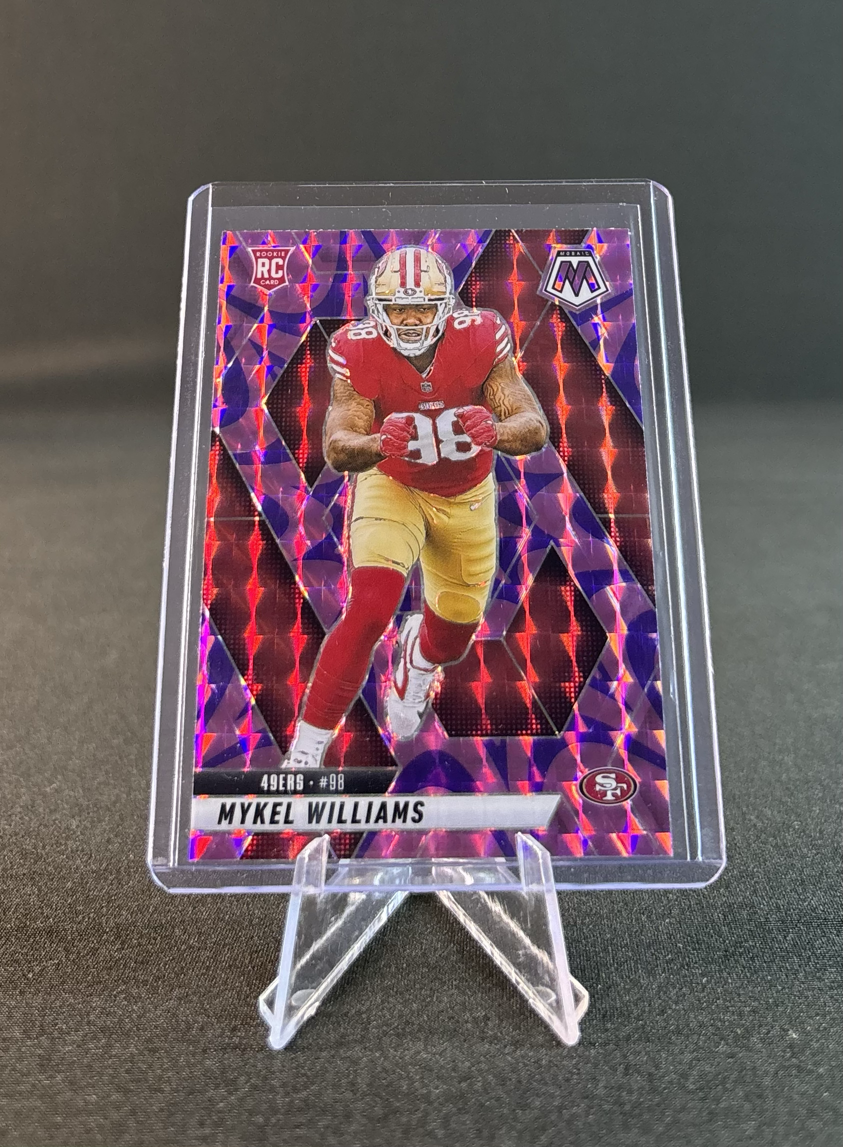 Holographic trading card featuring football player Mykel Williams in red and yellow uniform, with symbols indicating rookie card and team logo for San Francisco 49ers.