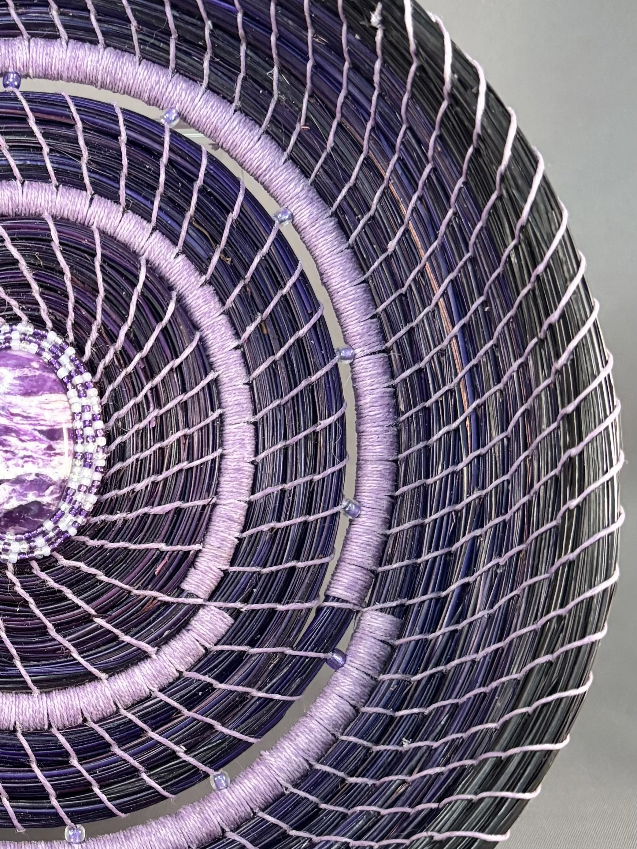 Detail of purple and black coiled pine needles and light purple glass beads on Lavender Resonance