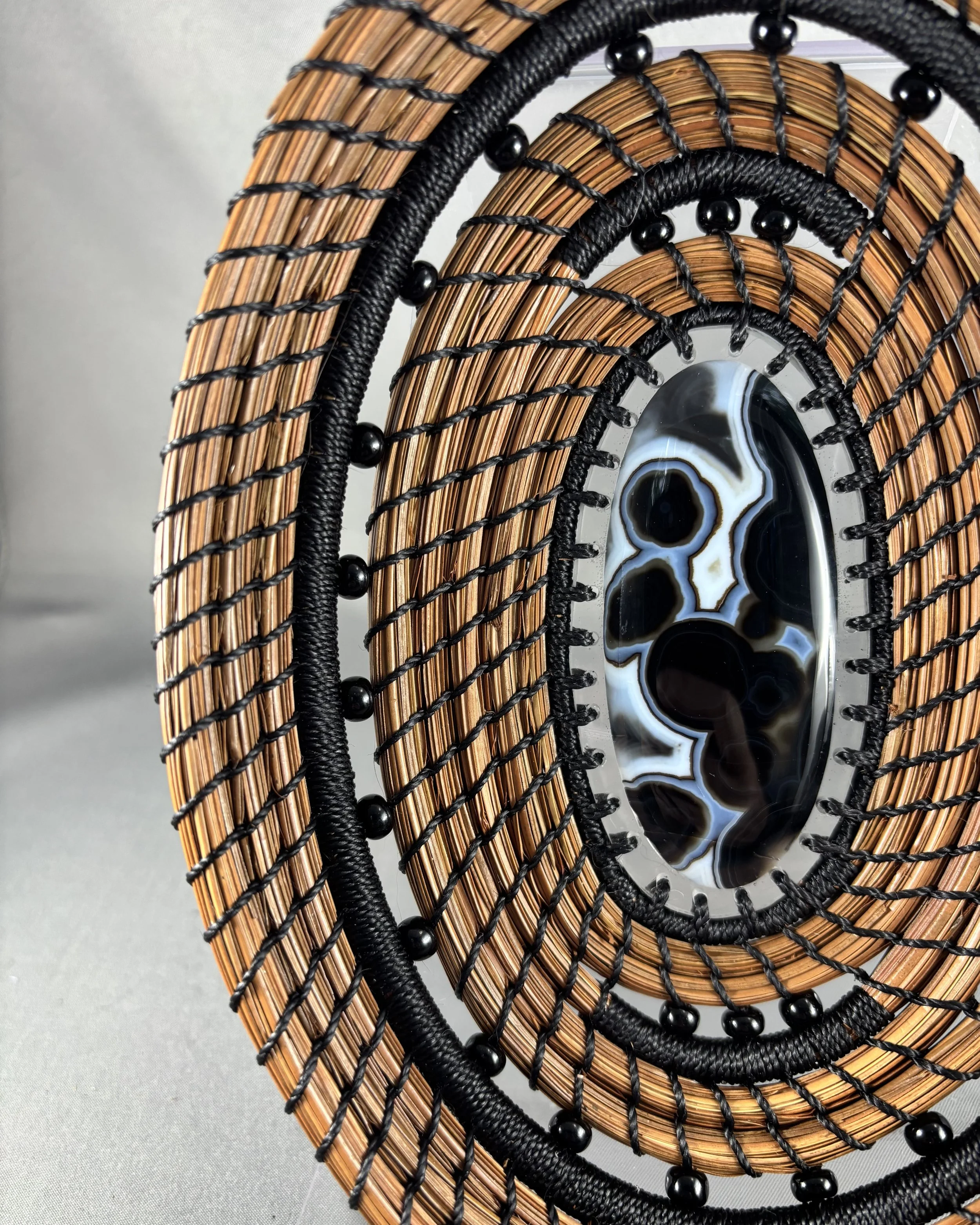 Detail of coiled longleaf pine needles, black stitching and beads on Dark Tides basket.