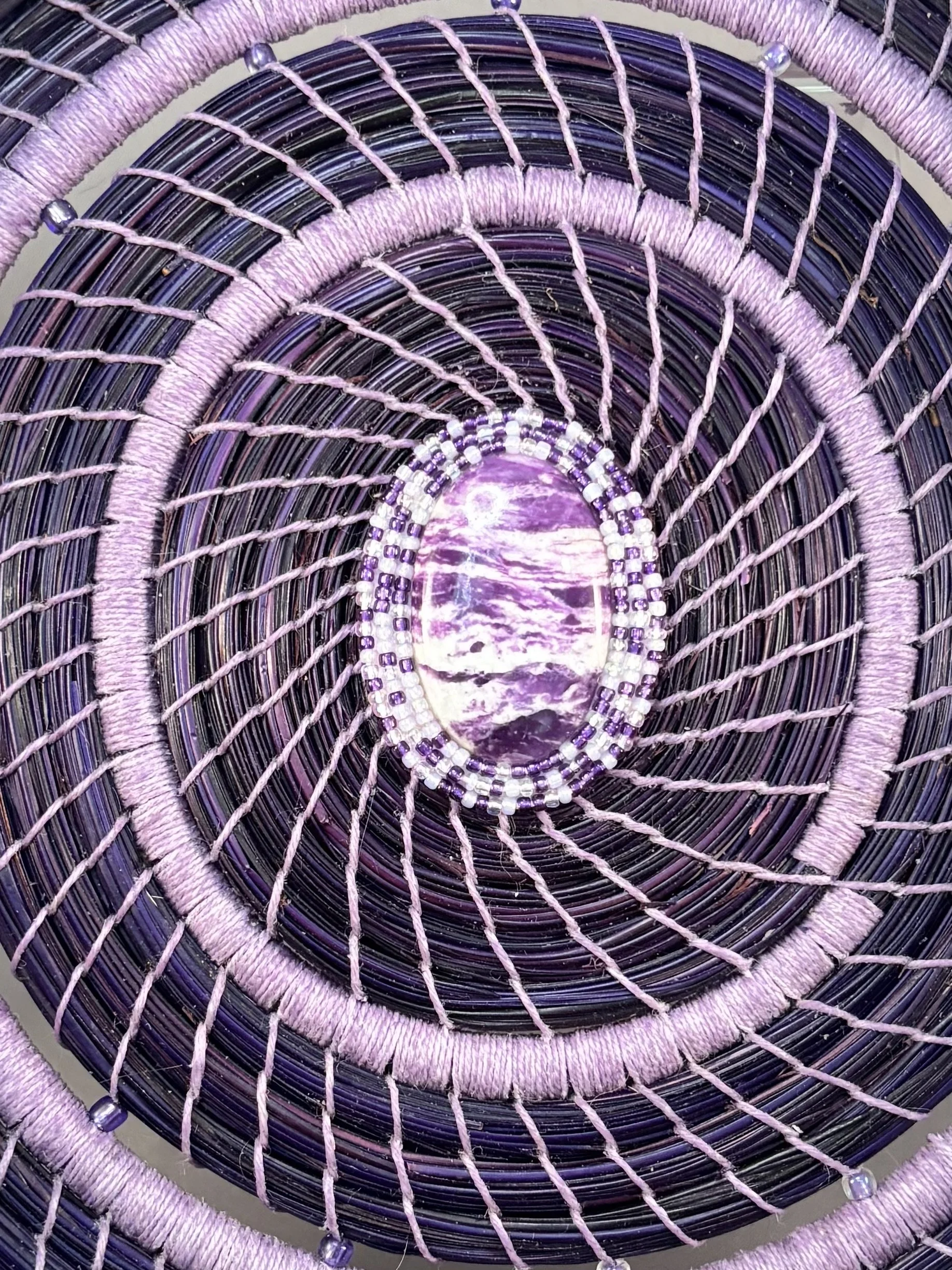 Detail of the kammererite center of Lavender Resonance, surrounded by three rows of individually stitched seed beads