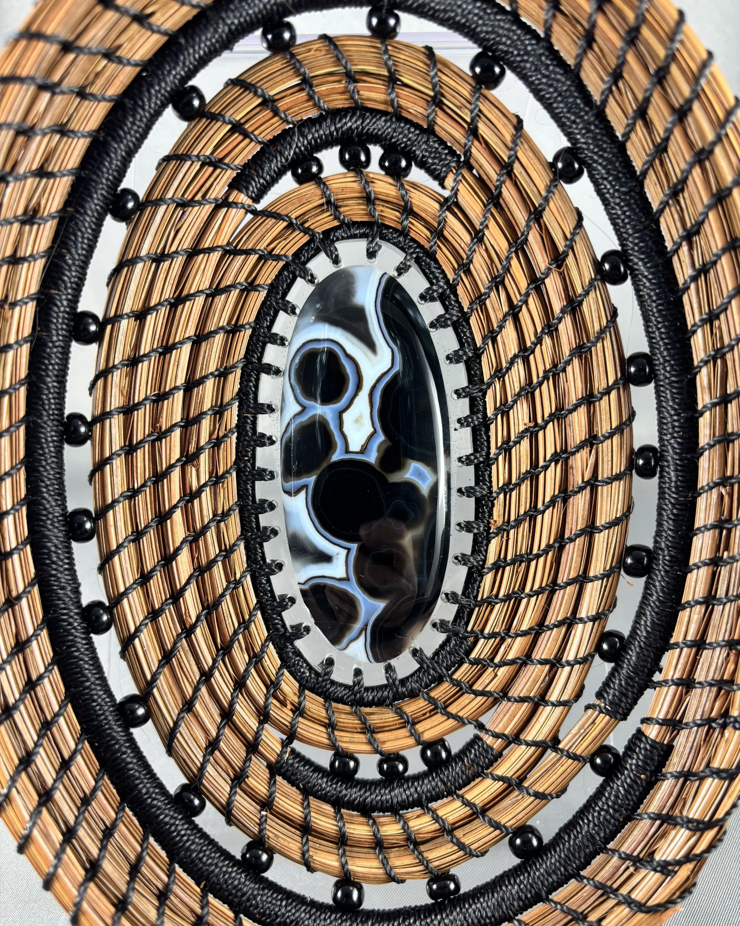 Close-up of Gobi eye agate center and black beadwork on Dark Tides pine needle basket