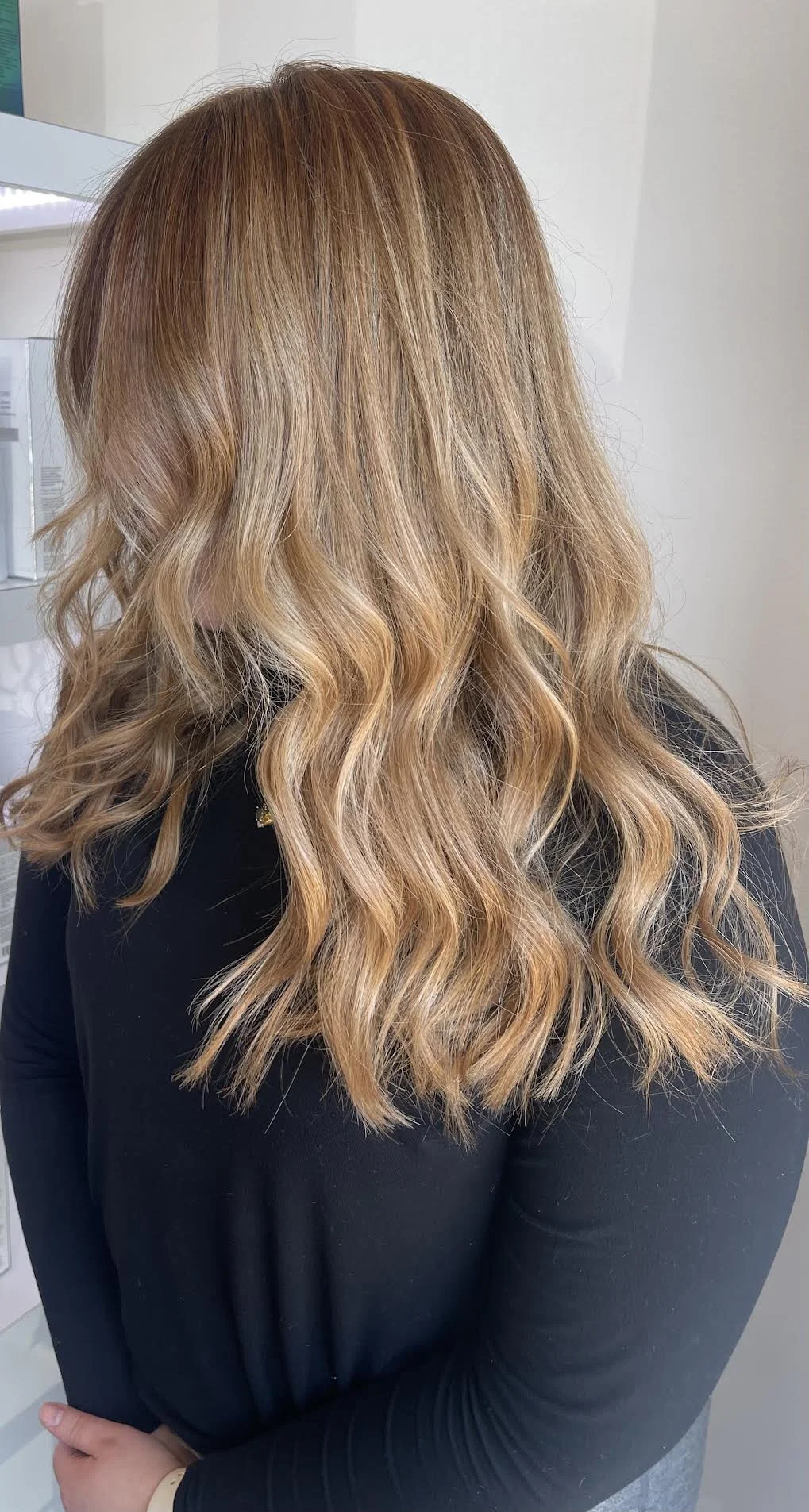 Back view of a woman with long, wavy, light brown hair.