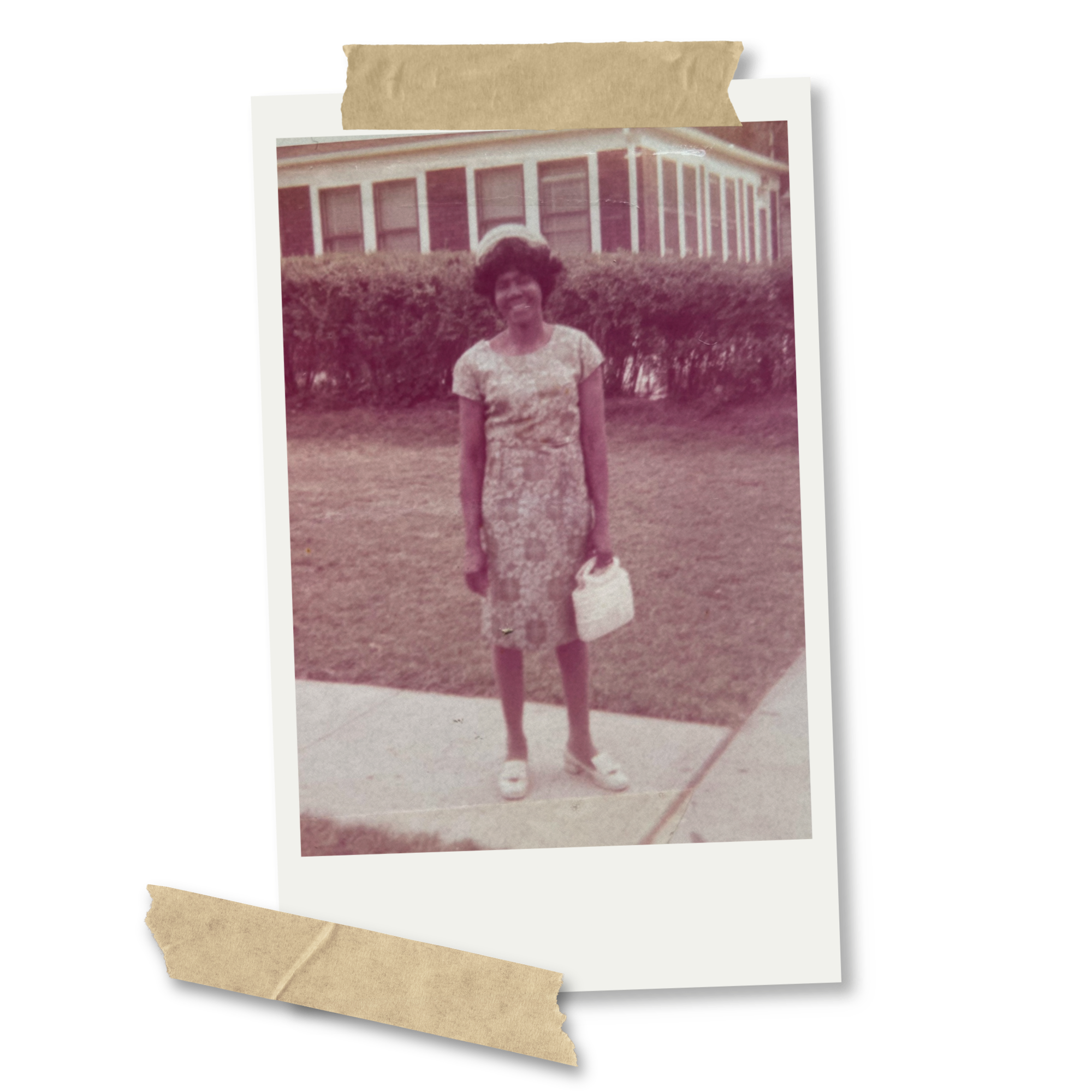 A vintage photograph of a young woman with curly hair, standing outdoors in front of a hedge and a large house with multiple windows and white columns, in sepia tone