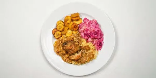 Plate with fried plantains, pink beet salad, and a meat dish with vegetables.