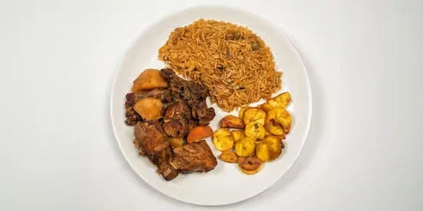 A plate of food with rice, cooked meat, and plantains.