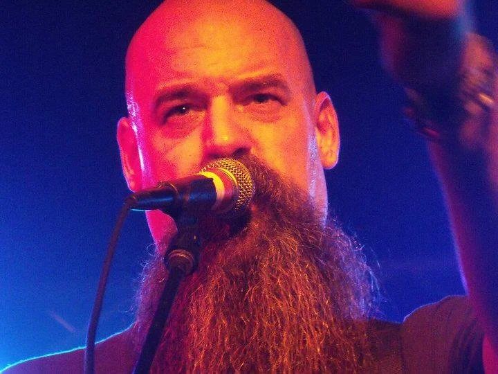 Close-up of Larry Holly singing under vivid concert lights