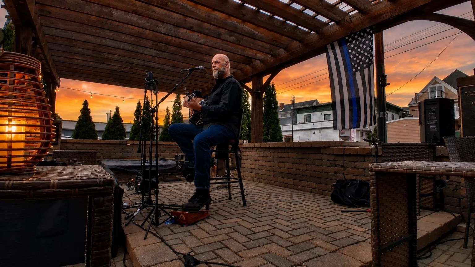 Larry Holly performing a solo acoustic set at sunset