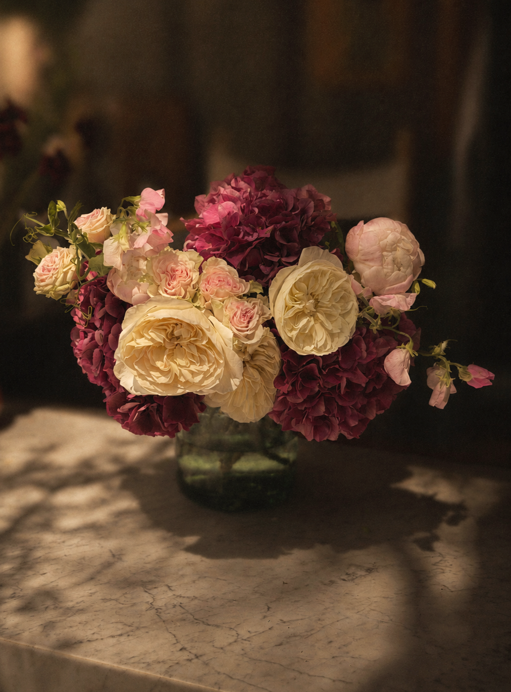 Garden-inspired pink and cream floral arrangement with roses, hyrdangeas, soft greenery, and layered textures.