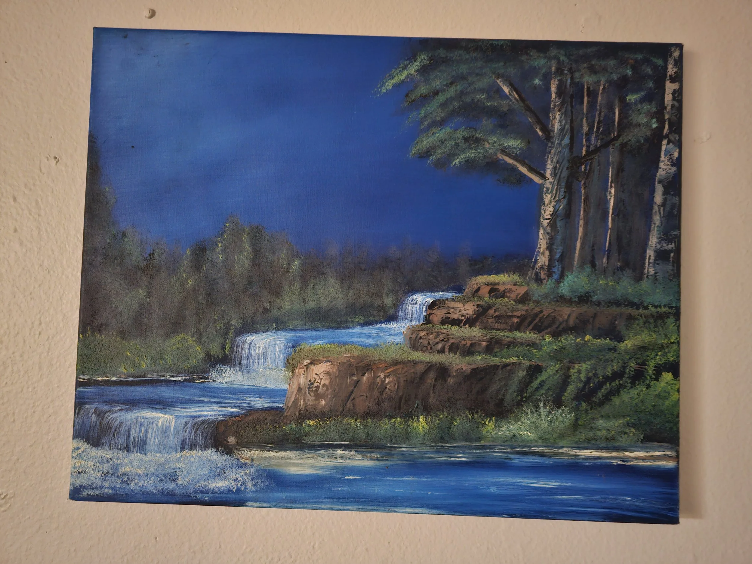 Landscape painting of a waterfall with trees and rocks under a dark blue sky.