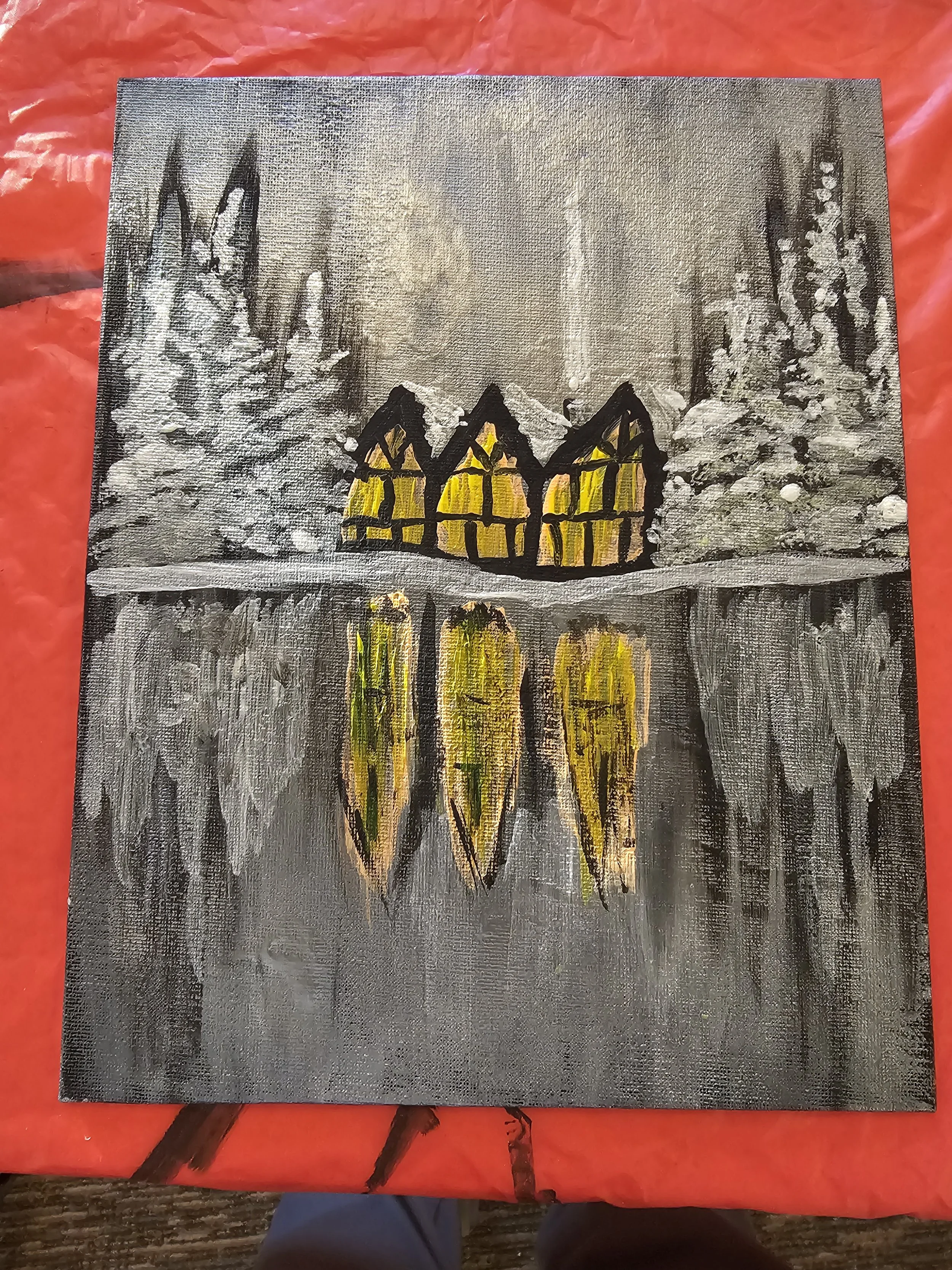 Painting of a snowy winter landscape with a small house with yellow windows, surrounded by snow-covered trees, and a reflection of the house in a frozen pond.