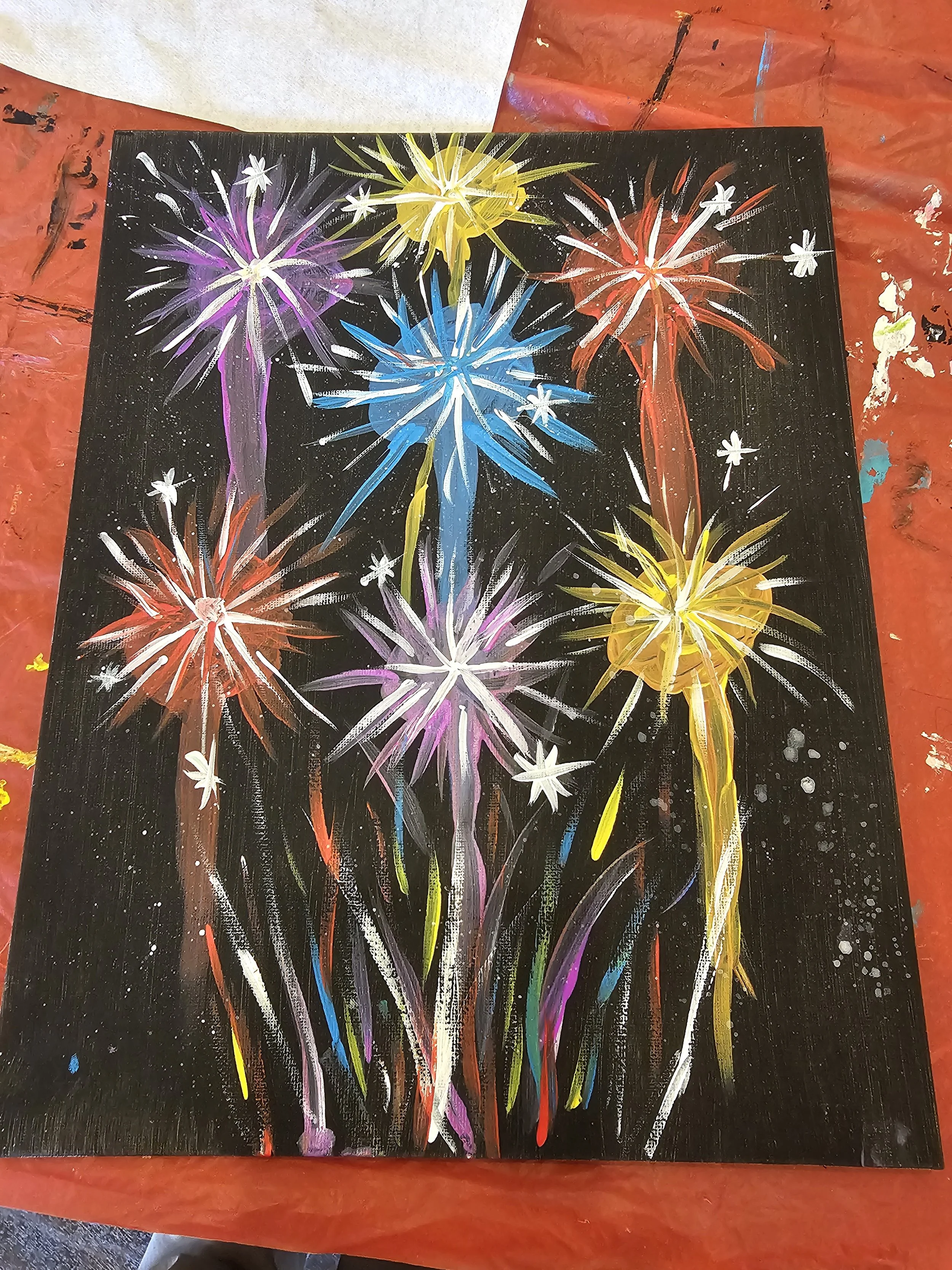 A colorful painting of fireworks on a black background, with several fireworks in various colors including purple, yellow, red, blue, and white.