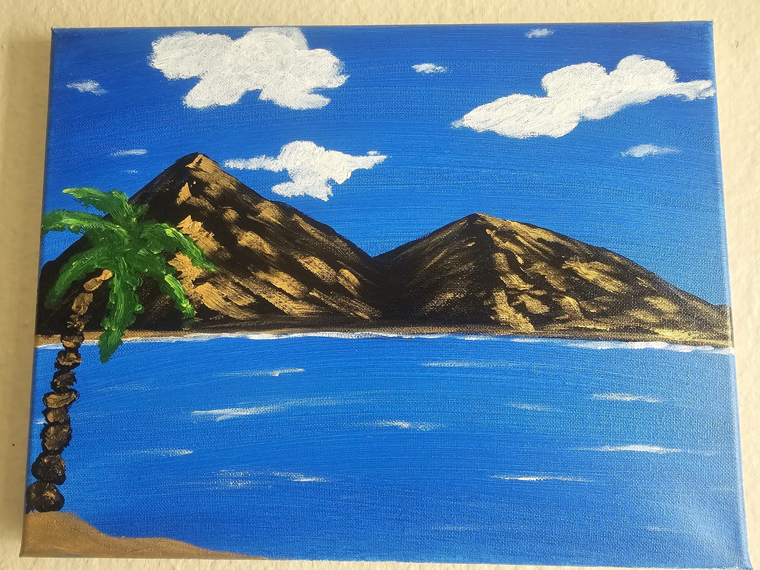 Painting of mountains, blue sky, white clouds, and a green palm tree on a canvas.