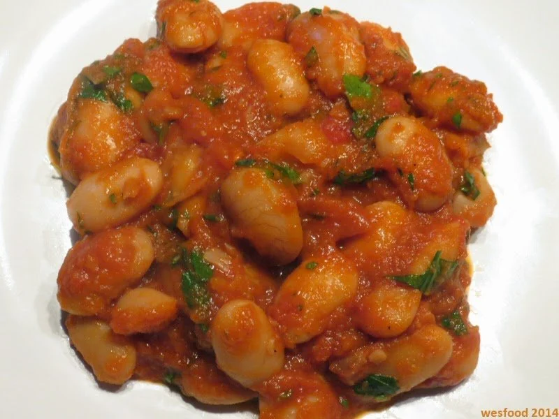 A plate of Greek gigandes beans cooked in tomato sauce.