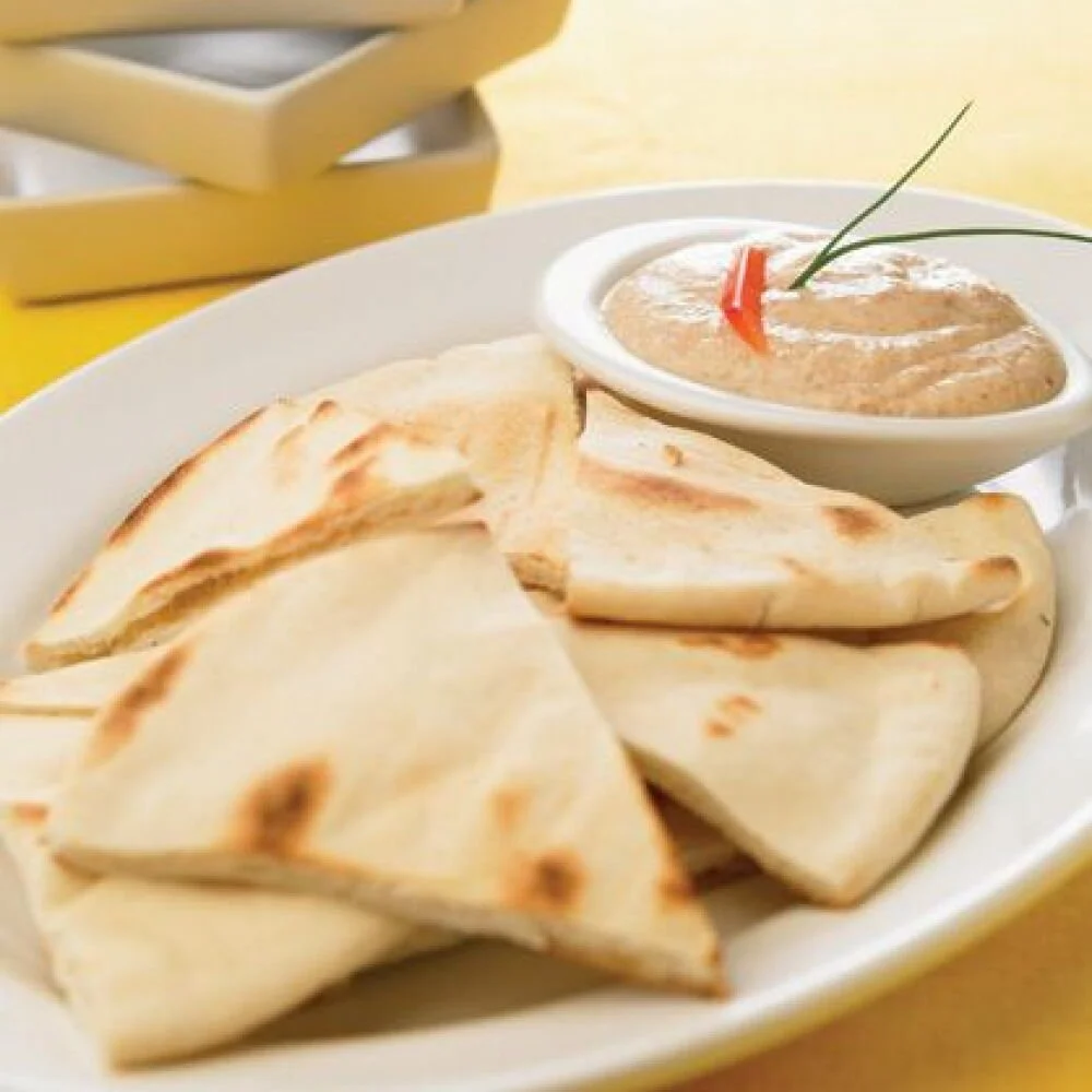 Plate of pita bread with a bowl of Greek taramasalata dip