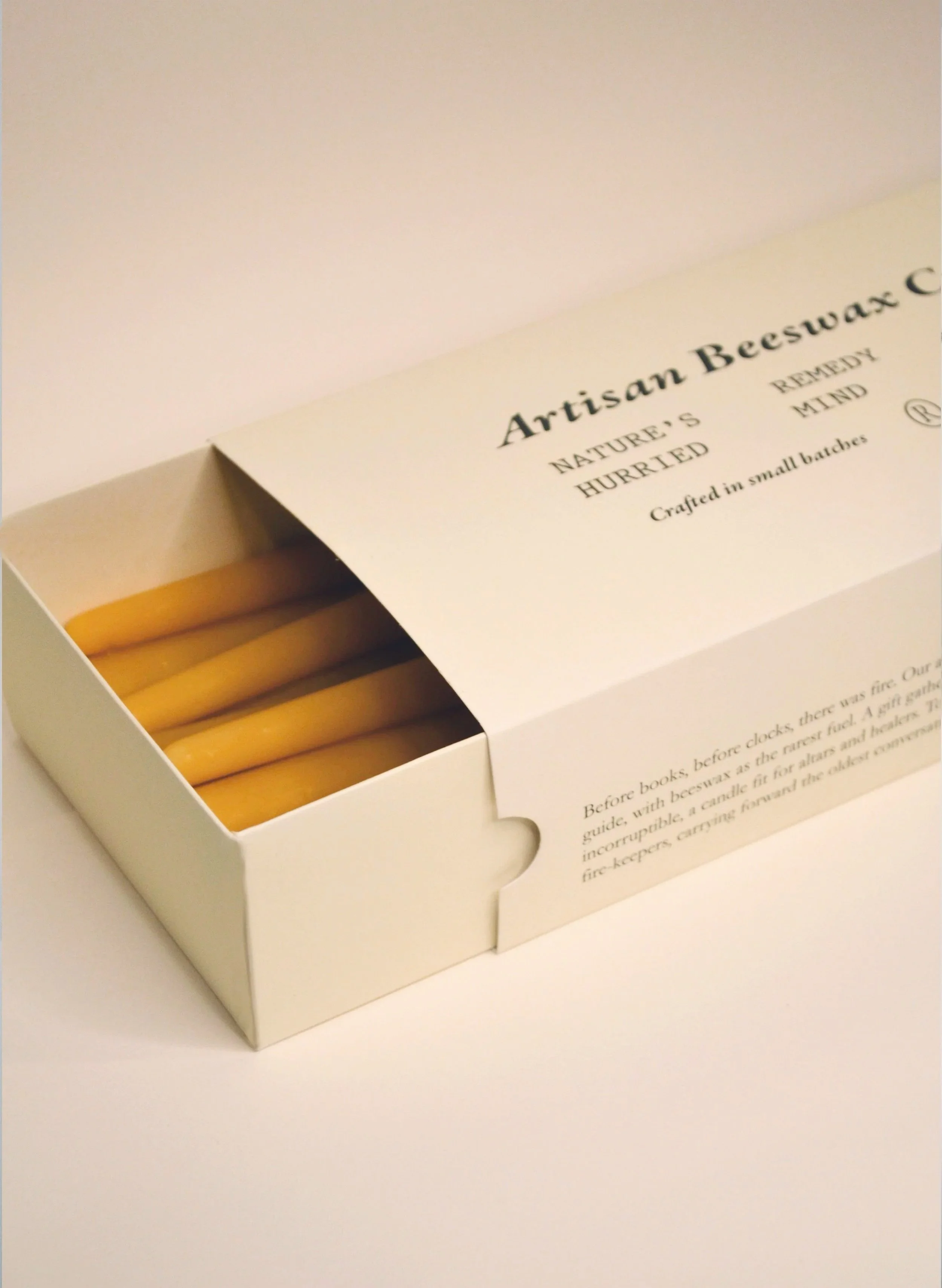 Handmade beeswax taper candles with a soft round tapered shape, grouped in an eco friendly box