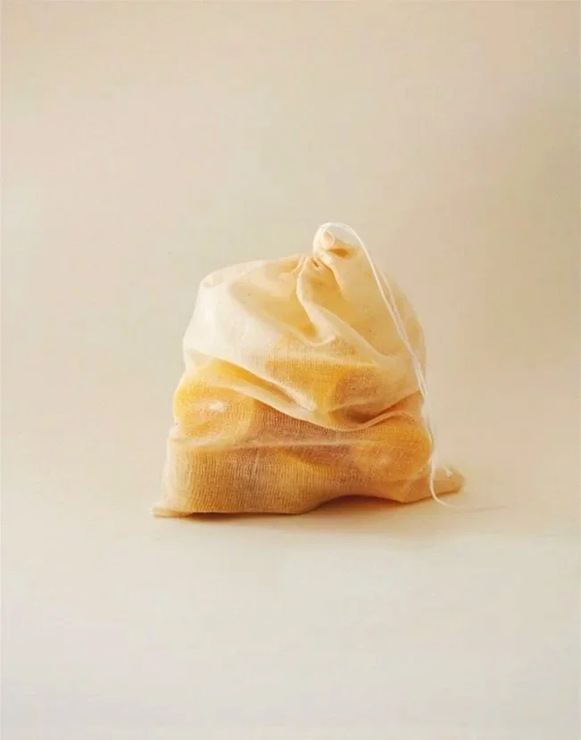 Pure beeswax no waste tea light candles with cotton wicks inside a natural cotton muslin pouch.