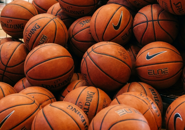 A pile of basketballs, with visible brand logos including Spalding and Nike.