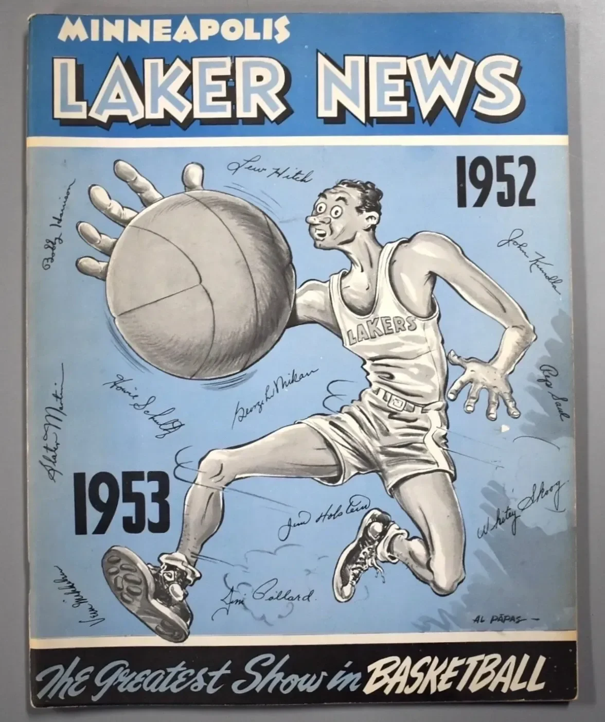 A vintage cover of Minneapolis Lakers basketball newsletter from 1952-1953 featuring a cartoon basketball player with exaggerated facial features, wearing a Lakers jersey, jumping and holding a basketball, surrounded by autographs of players.