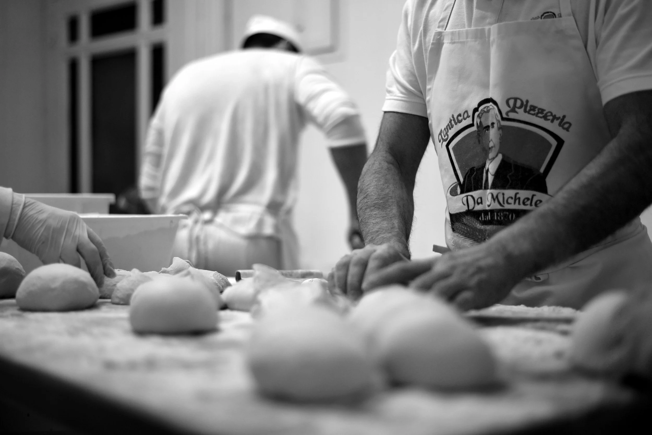 Historic photo of Neapolitan Pizzaiolo hand-shaping pizza dough at L'Antica Pizzeria da Michele in Naples.