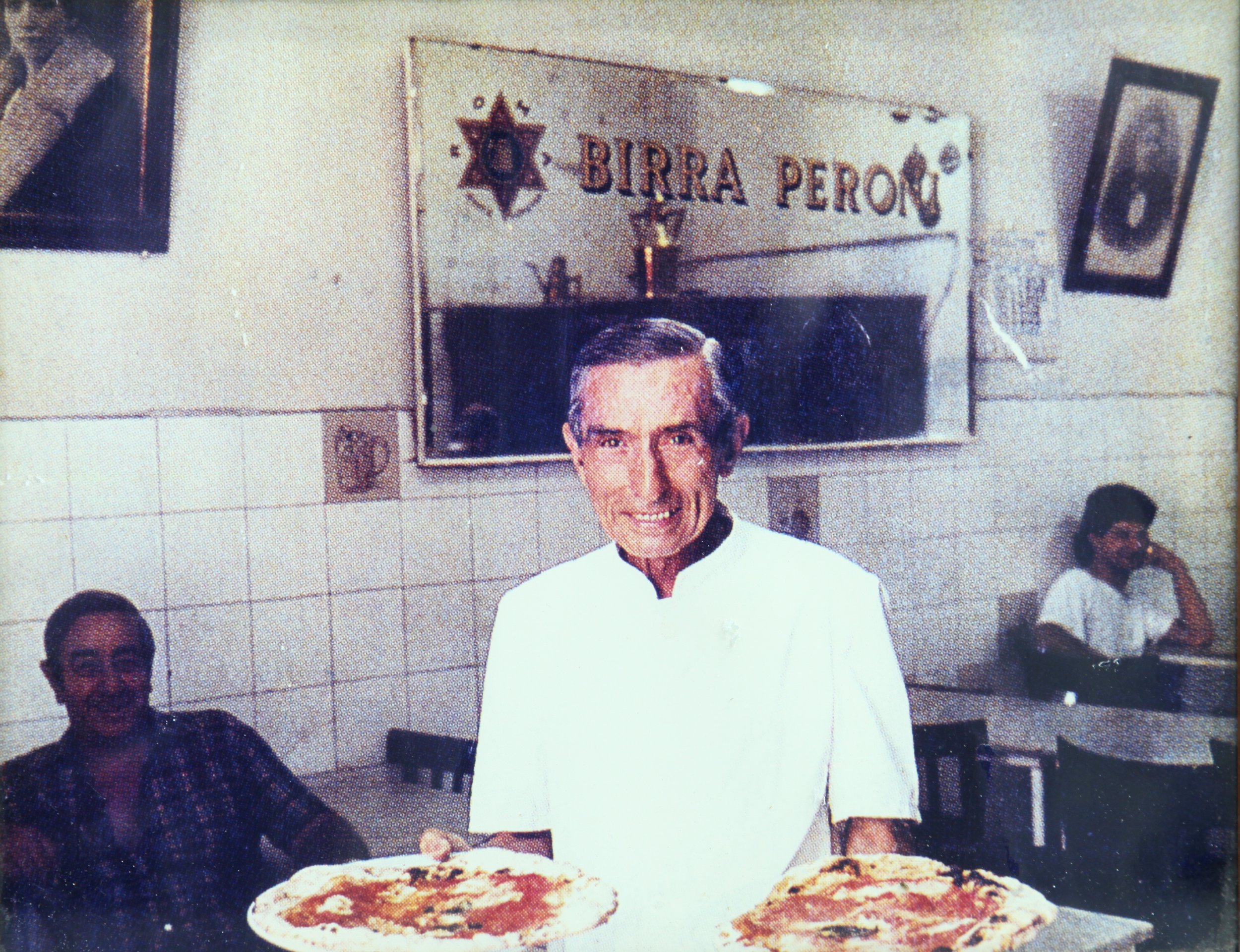 Historic Pizzaiolo preparing pizza at L'Antica Pizzeria da Michele in Naples.