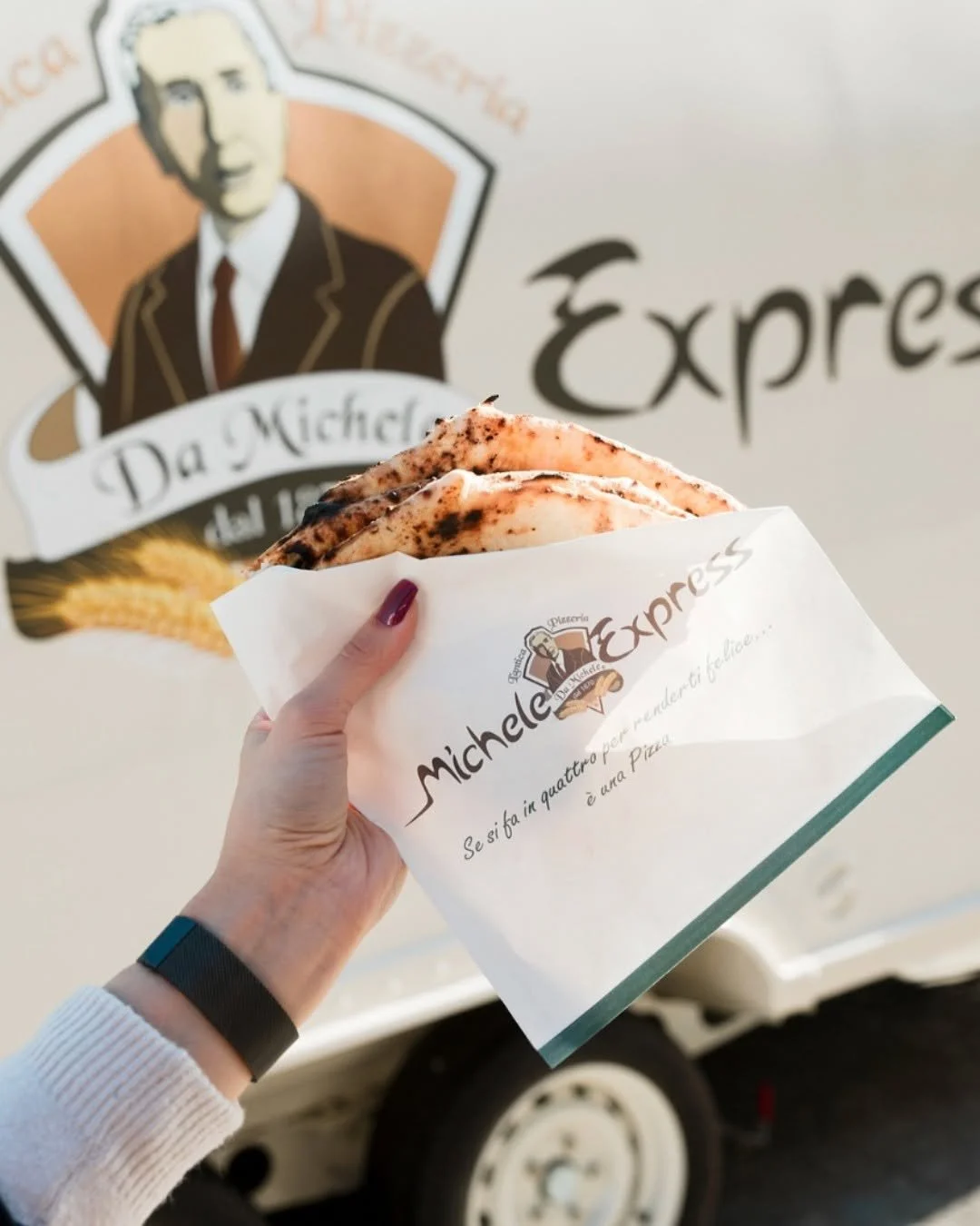 Pizza a portafoglio wrapped in Michele Express branded paper.