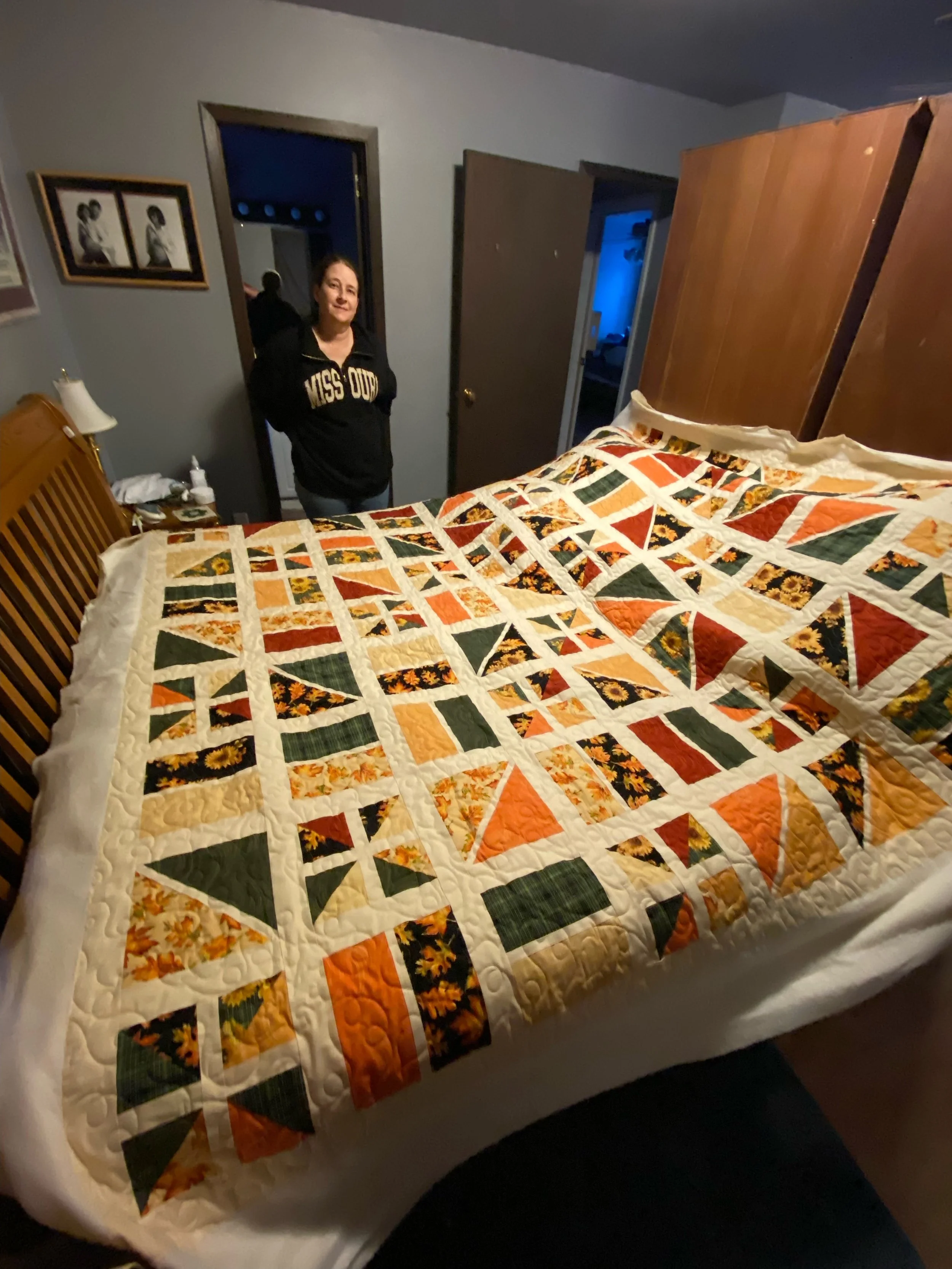 Colorful quilt featuring a patchwork design with autumn leaves, pumpkins, and geometric patterns.
