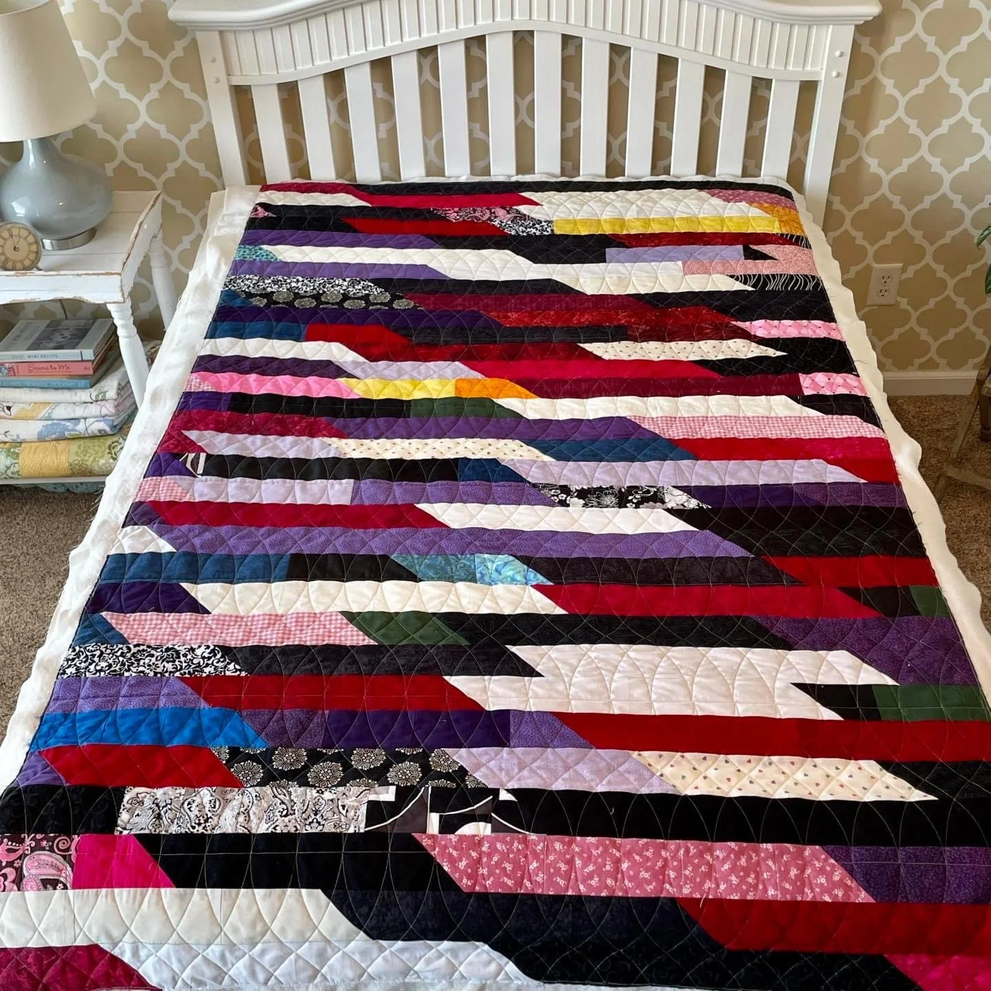 Colorful quilt with geometric patterns multiple colors.