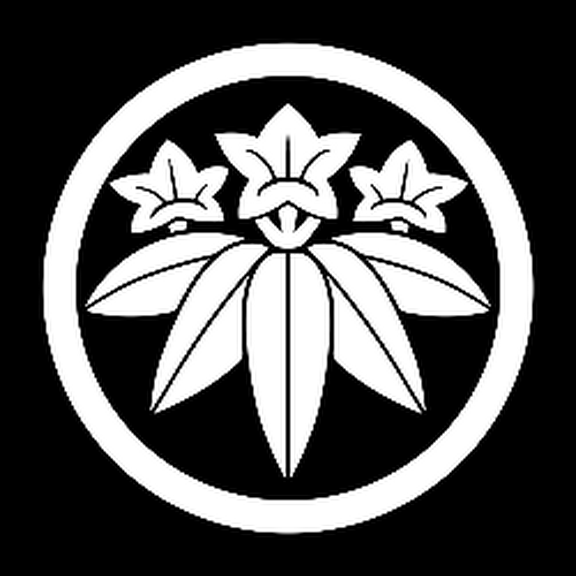 A black and white circular emblem with a stylized flower and leaf design inside.