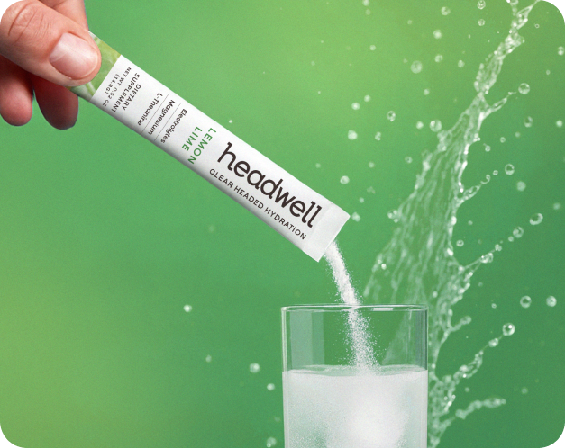 Headwell hydration packet being emptied into a glass of water