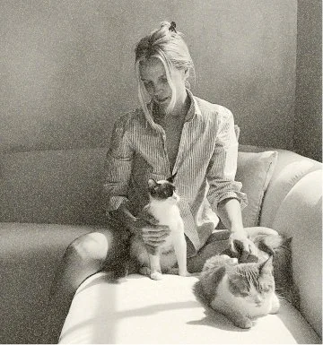 Headshot of Alison Wu sitting on a couch with her cats