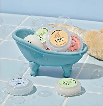 Mini Curie deodorant in a mini blue clawfoot tub for a creative brand photoshoot