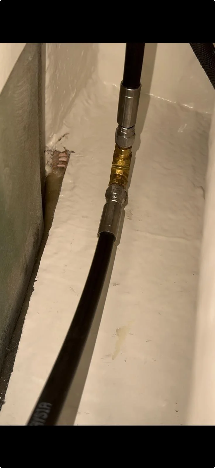 Leaking high-pressure boat water line alongside an unsealed and unglassed bulkhead identified during mobile leak diagnosis on the Gold Coast