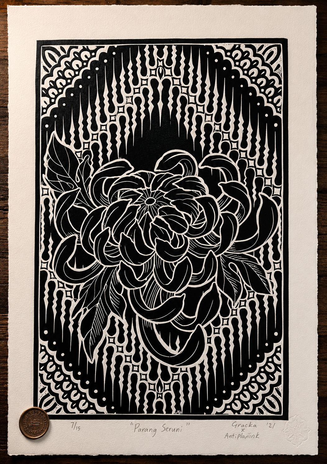 A black and white paper cut artwork titled 'Parang Seruni' depicting a large flower with detailed petals and leaves, surrounded by a decorative geometric border with dripping patterns at the top.