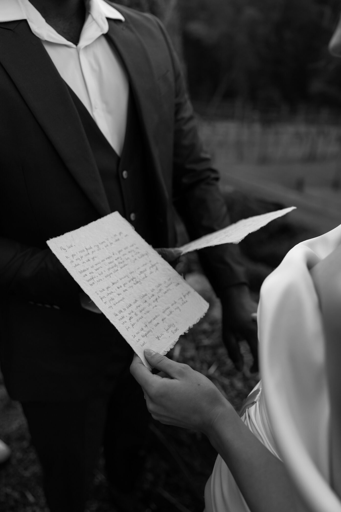 couple-reading-vows-hands-bw.jpg