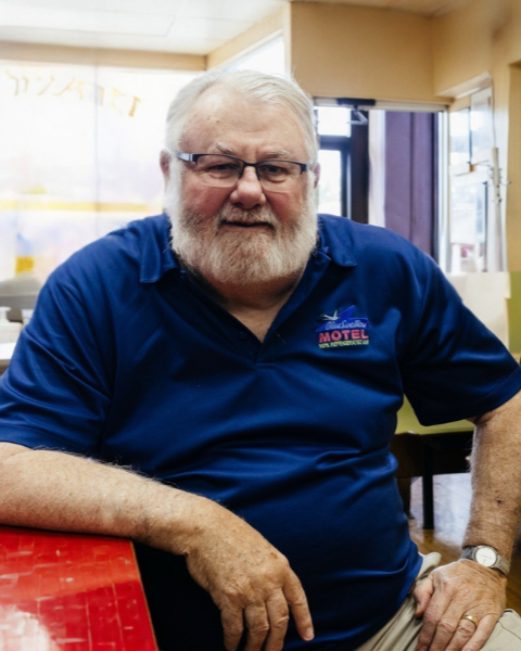 Larry Lankton in a Route 66 motel shirt sitting in a coney island cafe.