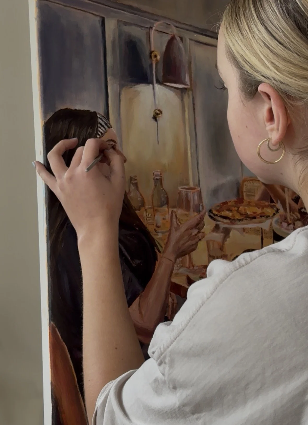 An artist painting a woman holding a drink on a table in a restaurant or café scene